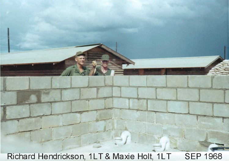 Rich Hendrickson and Maxie Holt (w/ beers) inspecting the latrine wall we were building. You do know that we (John Stewart, me , Maxie and many other officers) built those 2 running water latrines in officer country? Quite a story there!
